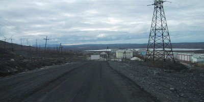 Dauður jarðvegurinn allt í kringum nikkelverksmiðjuna í Nikel. Í fjarska sést Noregur og þar eru iðjagrænir skógar um allt. Mynd Henri Berguis. 
