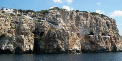 Næturklúbbur inni í klettaskútum við snarbratta klettalengju á Menorca. Mynd MontaNito